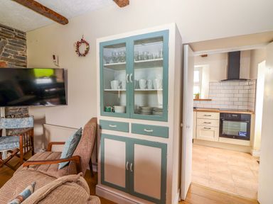 A living room with a shelving unit and television at The Farmhouse in Tralee, County Kerry