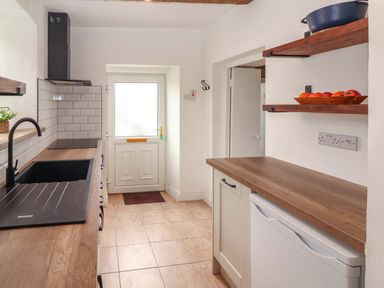 A kitchen with a sink and door at The Farmhouse in Tralee, County Kerry