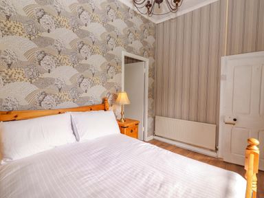 A bedroom with a bed and lamp at The Farmhouse in Tralee, County Kerry
