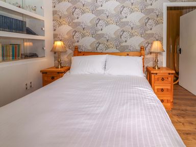 A bedroom with wooden furniture and a collection of books at The Farmhouse in Tralee, County Kerry