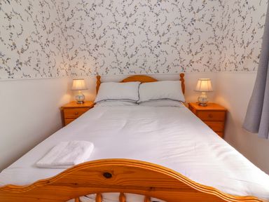 A bedroom with a bed and bedside tables at The Farmhouse in Tralee, County Kerry