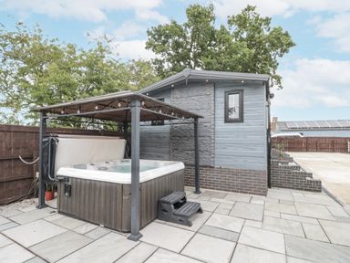 An outdoor area with a hot tub and patio at The Cabin in Thornton Dale