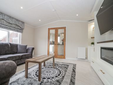A living room with a sofa and coffee table at The Cabin in Thornton Dale