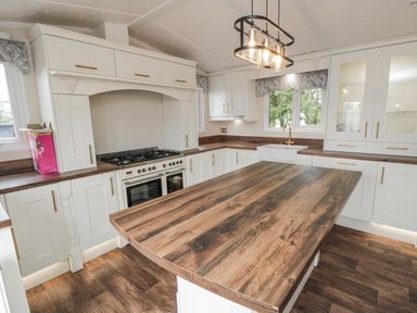 A kitchen with a large island and oven at The Cabin in Thornton Dale