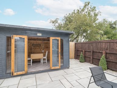 A garden shed with a table and chairs at The Cabin in Thornton Dale