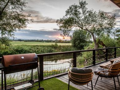 An outdoor area with a barbecue grill and chairs at The Red House in Farndon