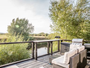 An outdoor area with a sofa and grill at The Larch House in Farndon