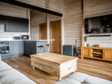 A living room with kitchen cabinets and a coffee table at The Larch House in Farndon
