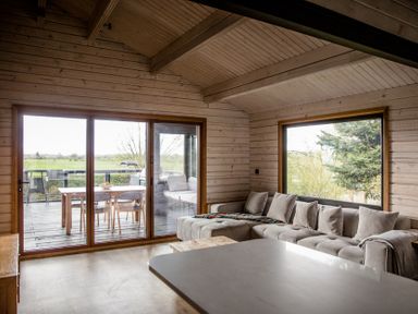 A living room with a sofa and dining area at The Larch House in Farndon