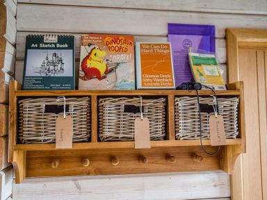 Shelves with books and storage baskets at The Larch House in Farndon
