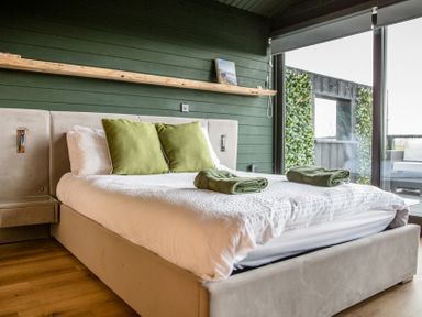 A bedroom with a bed and wooden shelf at The Larch House in Farndon