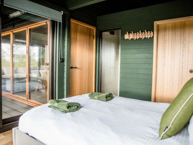 A bedroom with a bed and towels at The Larch House in Farndon