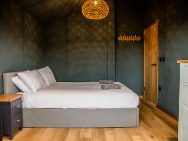 A bedroom with a bed and nightstand at The Larch House in Farndon