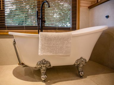 A bathtub with a towel draped over it at The Larch House in Farndon