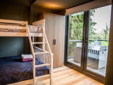A bedroom with a bunk bed and wardrobe at The Larch House in Farndon