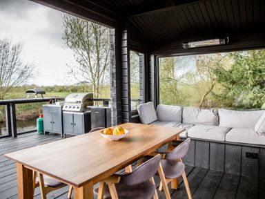 An outdoor patio with table and seating area at The Larch House in Farndon