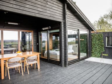 An outdoor patio with a dining table and chairs at The Larch House in Farndon