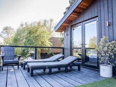 A deck with chairs and loungers at The Larch House in Farndon