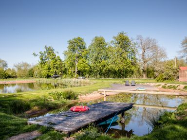 An outdoor area with a pond and dock at The Larch House in Farndon
