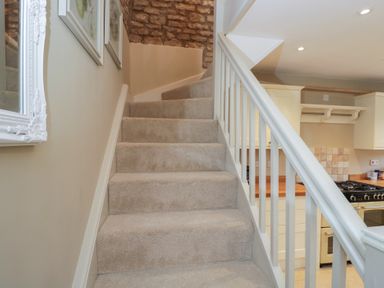 A staircase leading to a kitchen at Granary Cottage