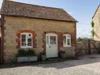 An exterior view of a cottage with plants outside at Granary Cottage in Lacock