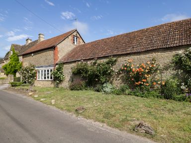 A cottage with flowers along the wall at Granary Cottage in Lacock