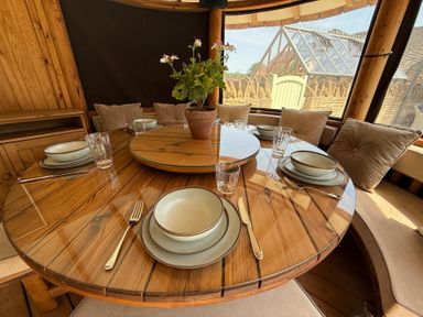 A dining table set with plates and cutlery at Granary Cottage in Lacock