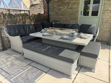 A seating area with a table and cushions at Granary Cottage in Lacock