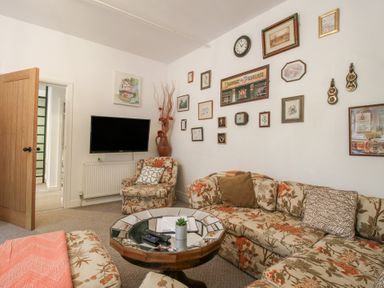 A living room with a sofa and television at Apartment 1 The Bridge at Stanford Hotel near Great Witley