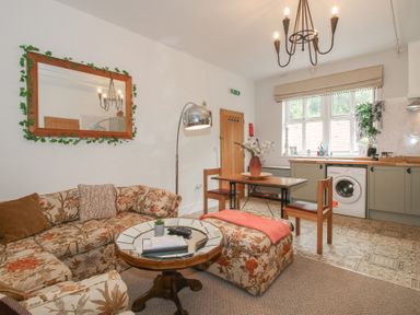 A living room with a sofa and table at Apartment 1 The Bridge at Stanford Hotel near Great Witley