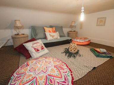 A snug with floor cushions and a sofa at Apartment 1 The Bridge at Stanford Hotel near Great Witley