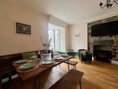 A dining room with a table set for a meal at Llanrwst Apartment