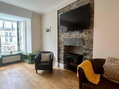 A living room with a sofa and fireplace at Llanrwst Apartment