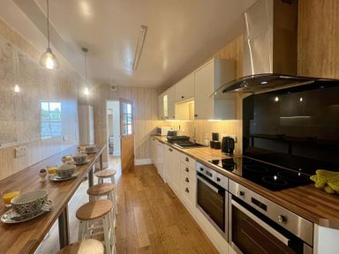 A kitchen with cabinets and a stove at Llanrwst Apartment