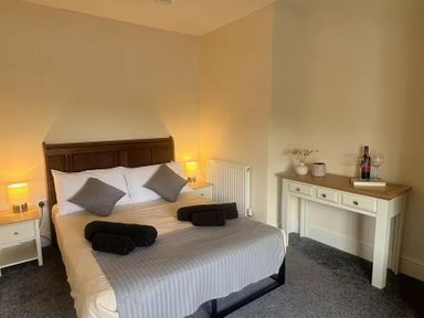 A bedroom with a bed and a desk at Llanrwst Apartment