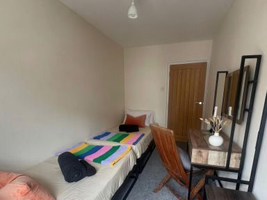 A bedroom with beds and a table at Llanrwst Apartment