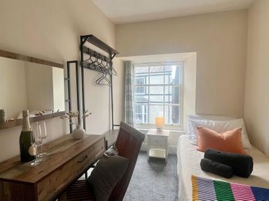 A bedroom with a bed, desk and window at Llanrwst Apartment
