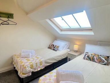 A bedroom with two beds and a skylight at Llanrwst Apartment