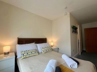 A bedroom with a bed and nightstand at Llanrwst Apartment