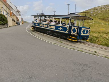 A tram traveling on a curved road at Mariners Lee in Llandudno
