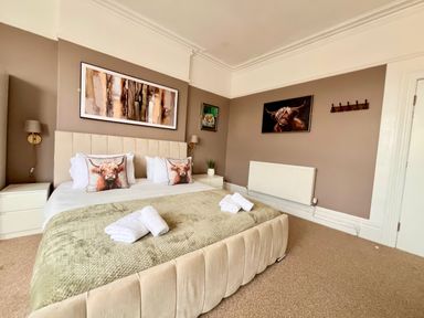 A bedroom with a bed and artwork at Clarence House in Llandudno