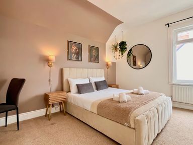 A bedroom with a bed and wall art at Clarence House in Llandudno