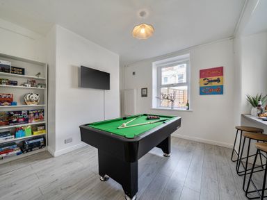 A game room with a pool table and television at Clarence House in Llandudno