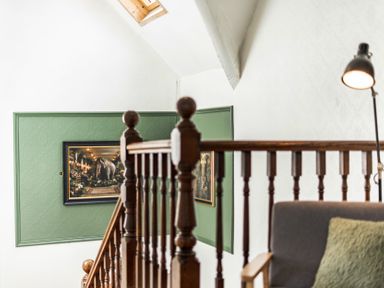 A staircase with a railing and a painting at Clarence House in Llandudno