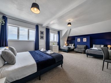A bedroom with two beds and windows at Clarence House in Llandudno