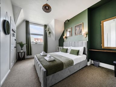 A bedroom with a bed and a window at Clarence House in Llandudno