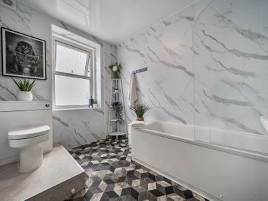 A bathroom with a bathtub and toilet at Clarence House in Llandudno