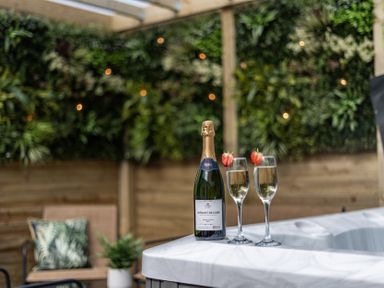An outdoor space with a bottle of sparkling wine and glasses at Clarence House in Llandudno