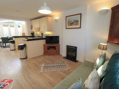 A living room with a sofa and television at Swirl Howe in Keswick