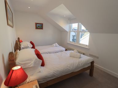 A bedroom with two beds and a window at Swirl Howe in Keswick